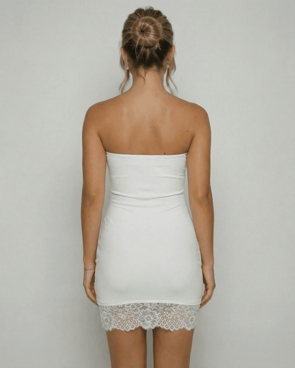 Back view of a woman wearing the Lauven Celeste Mini Dress, showcasing the strapless design and lace hem detail.