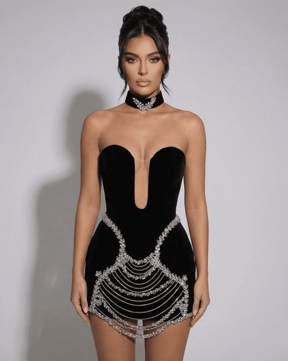 Stylish model wearing the SLIMONA Celeste Mini Dress featuring crystal rhinestone chain details and a deep V-neckline.