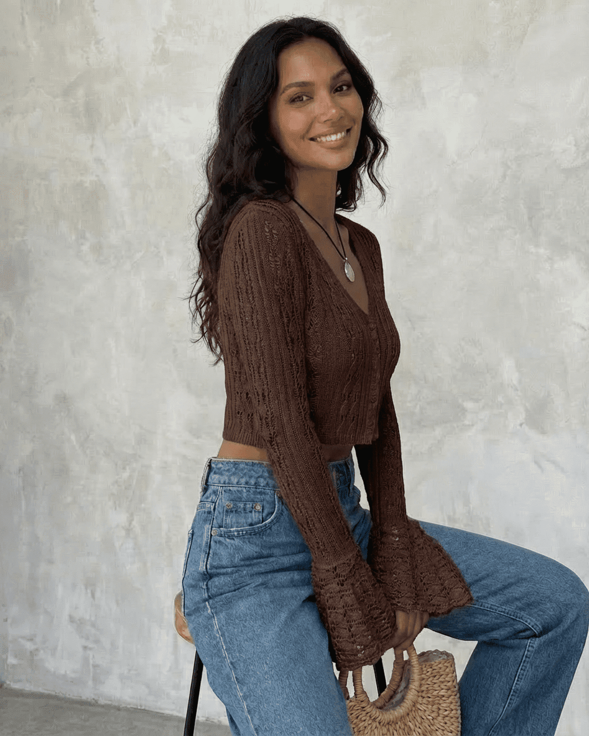 Model wearing the Cocoa Cardigan by SLIMONA, featuring a cropped design and flare sleeves in a rich brown color.