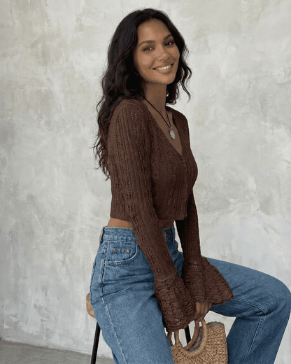 Model wearing the Cocoa Cardigan by SLIMONA, featuring a cropped design and flare sleeves in a rich brown color.
