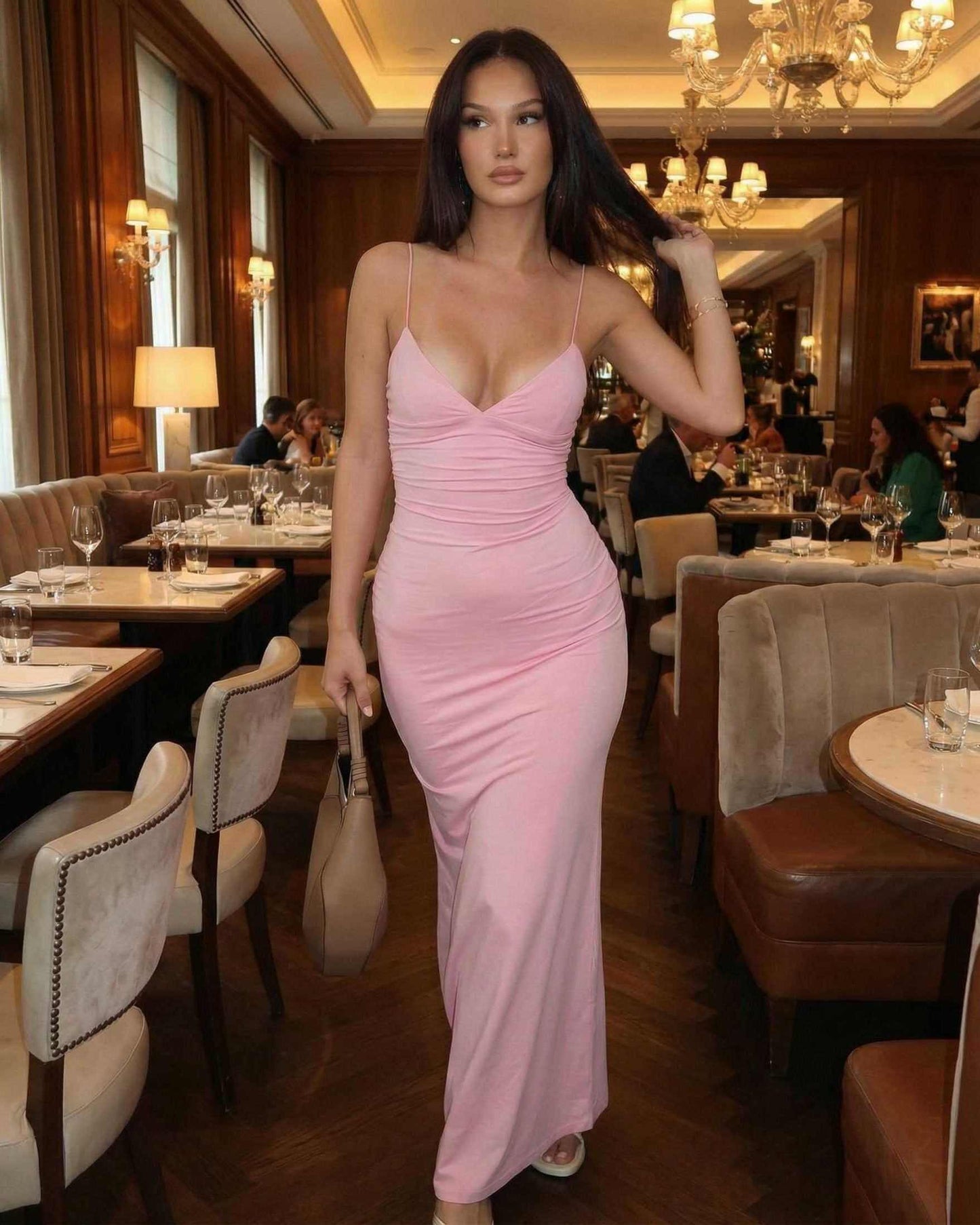 Elara Maxi Dress by SLIMONA, featuring a sleek sleeveless silhouette in soft blush-pink at an elegant restaurant.