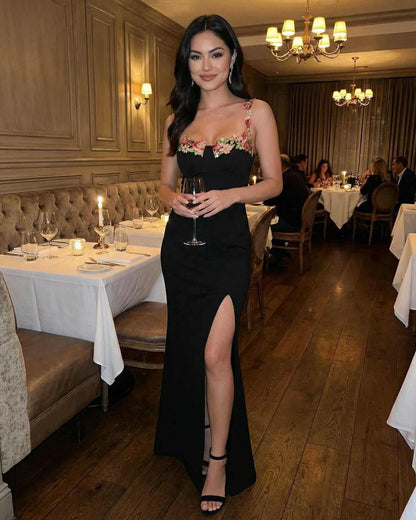 Florence Maxi Dress by Lauven — Embroidered black dress with elegant slit in a sophisticated dining setting.