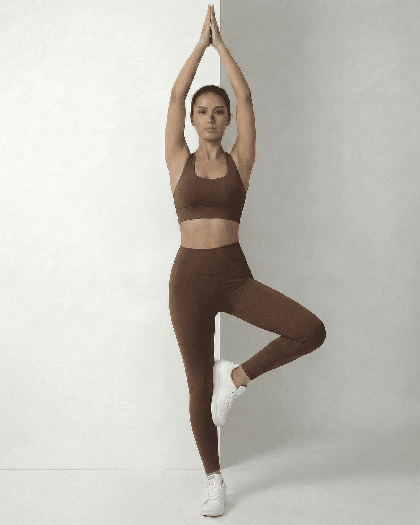 Model wearing Hazel Leggings by SLIMONA, showcasing sleek brown high-waist design in an active pose.