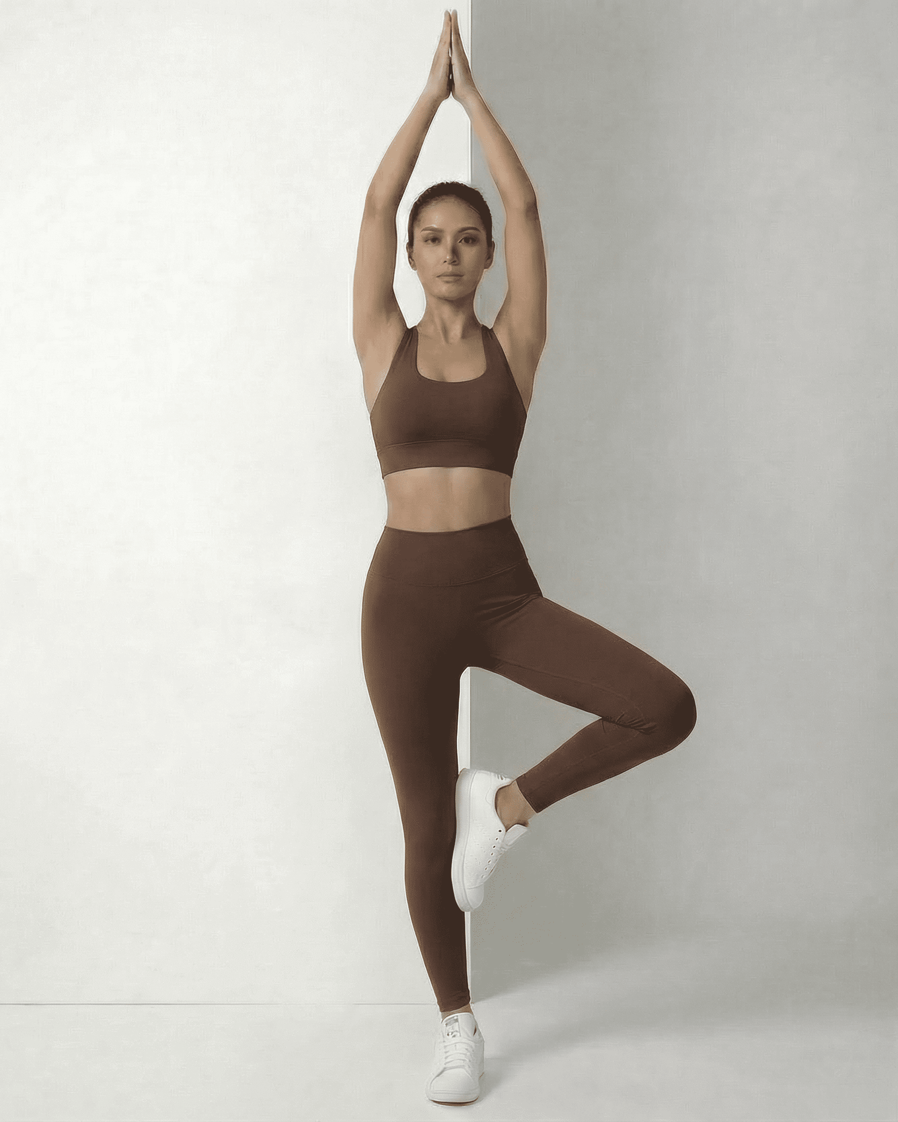 Model wearing Hazel Leggings by SLIMONA, showcasing sleek brown high-waist design in an active pose.