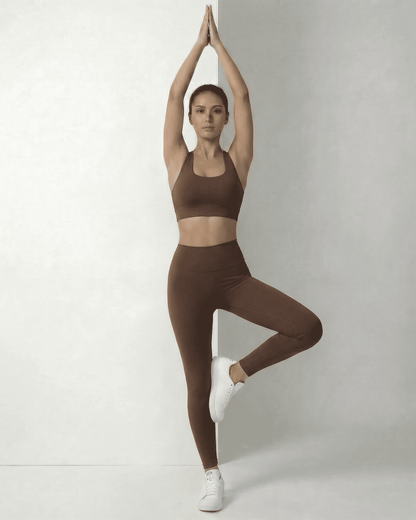 Model wearing Hazel Leggings by SLIMONA, showcasing sleek brown high-waist design in an active pose.