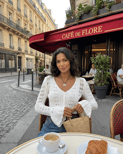 Model wearing Laceflare Cardigan by SLIMONA, enjoying coffee at Café de Flore with stylish flare sleeves.