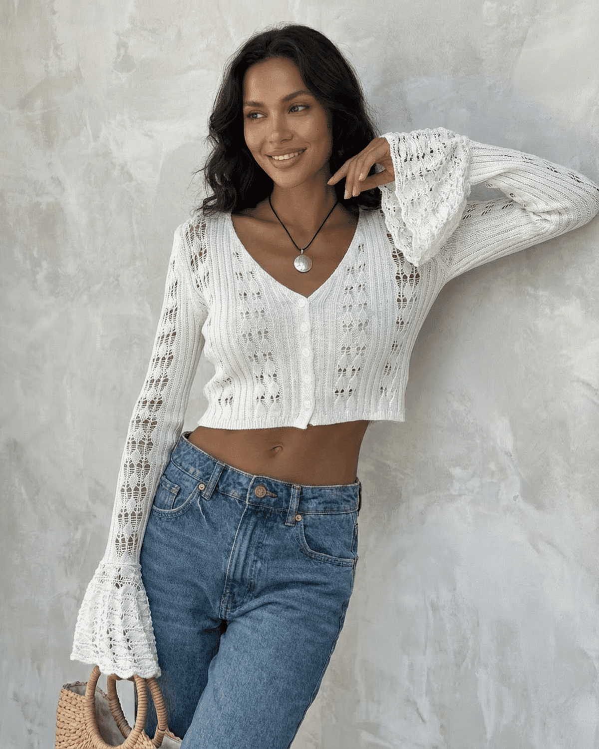 Model wearing Laceflare Cardigan by SLIMONA, featuring flare sleeves and V-neck, styled with high-waisted jeans.