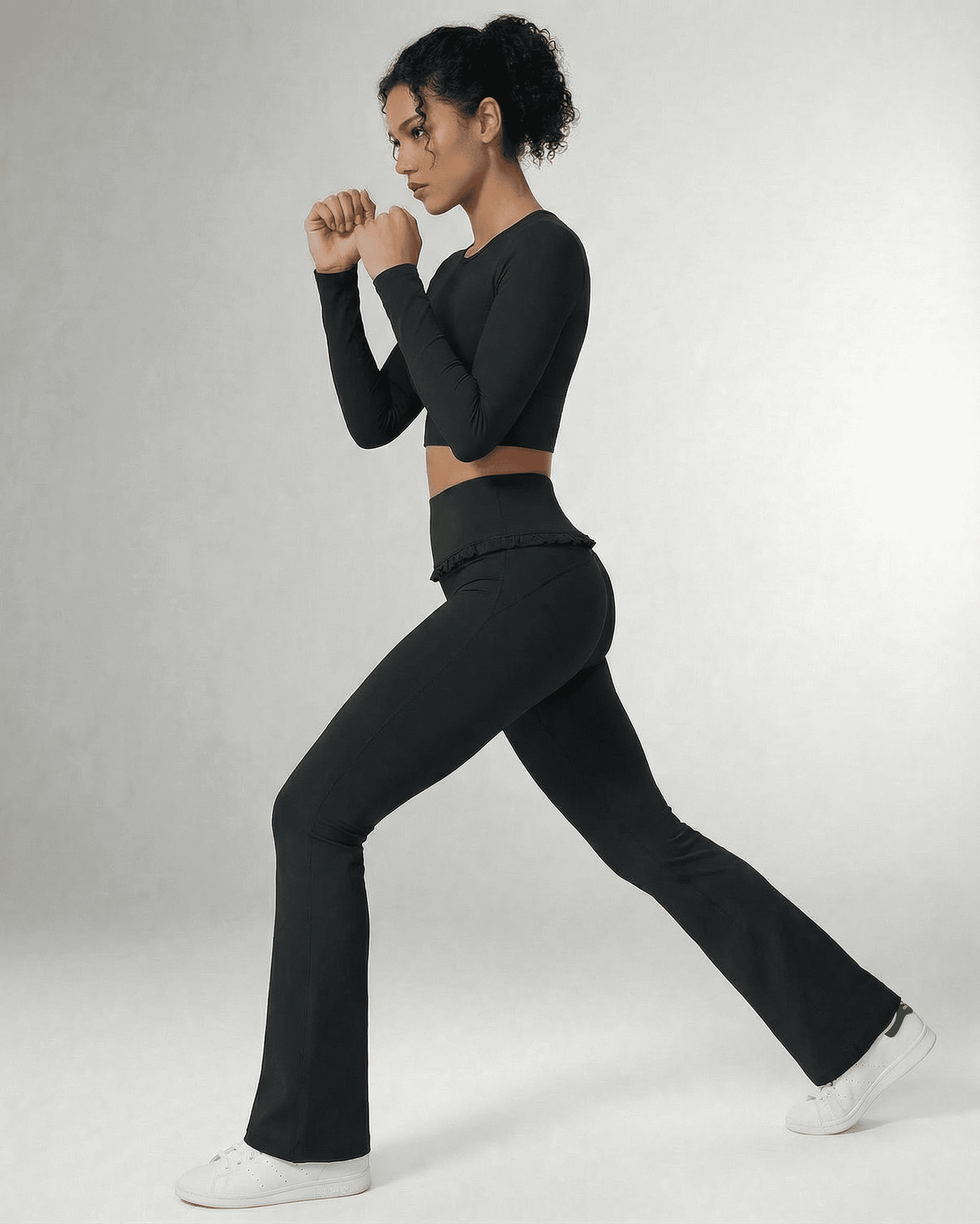 Model wearing Luna Leggings by SLIMONA, showcasing sleek black flare pants with pockets and a flattering high-waist design.