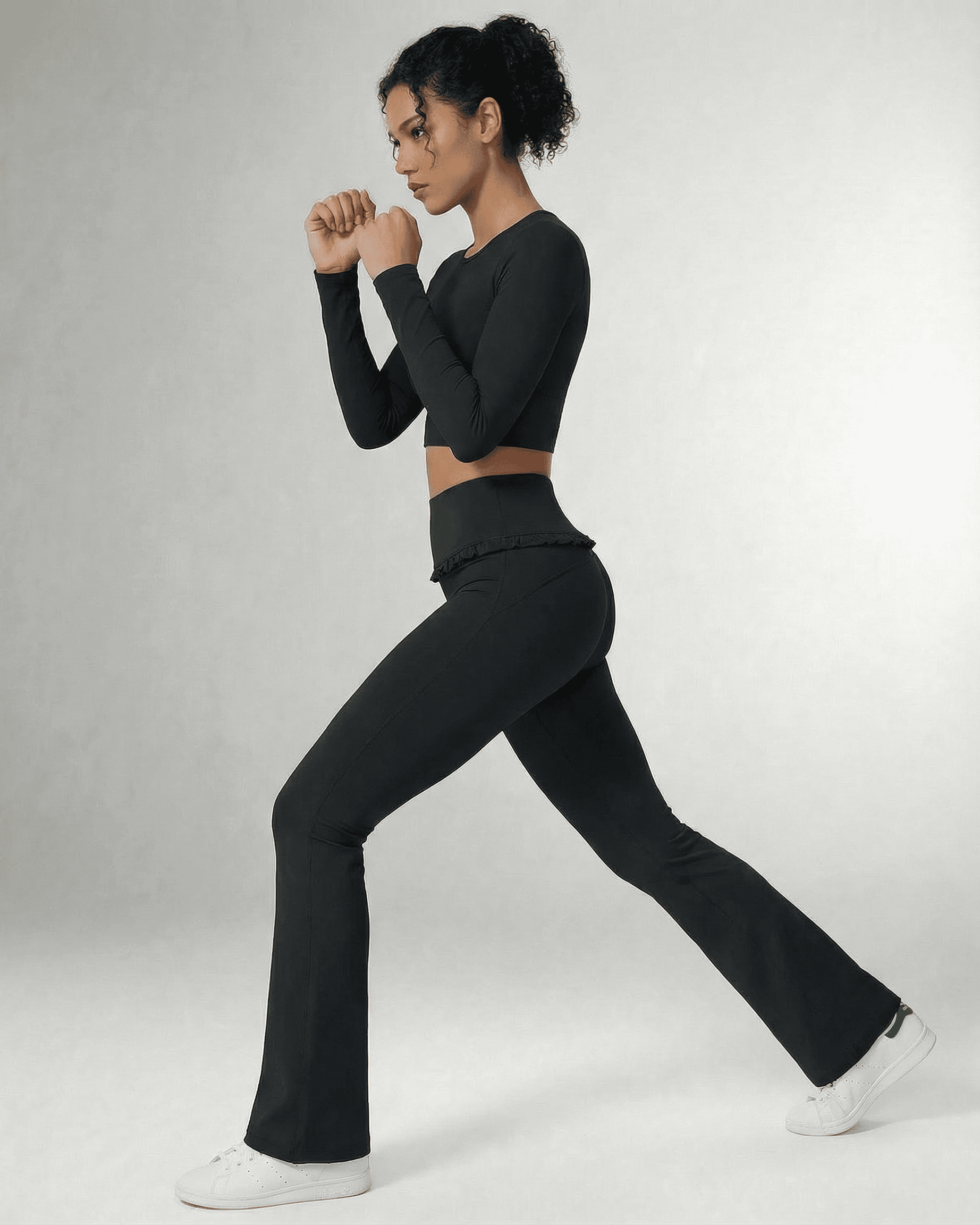 Model wearing Luna Leggings by SLIMONA, showcasing sleek black flare pants with pockets and a flattering high-waist design.