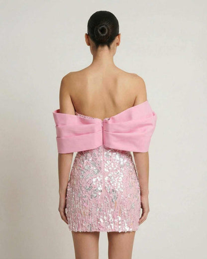 Lauven Luna Mini Dress in pink sequins, strapless with an elegant off-the-shoulder draped detail, showcasing the back view.