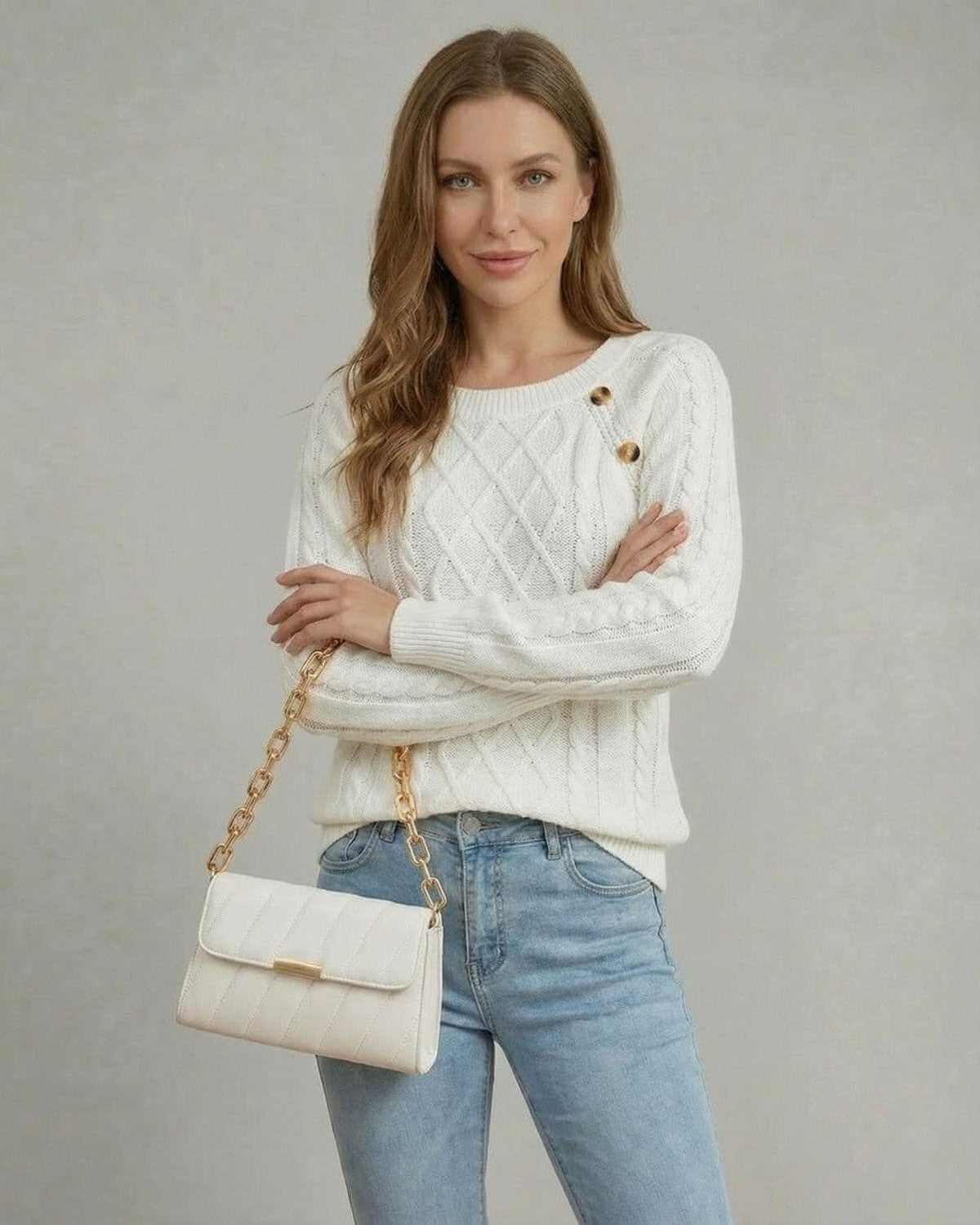 Model wearing the Luna Pullover by SLIMONA, featuring a cable knit design and holding a white handbag.