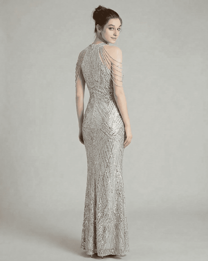 Luxe Maxi Dress by SLIMONA, showcasing a silver sequined halter gown with elegant beaded shoulder drapes.