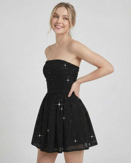 Lyra Mini Dress by SLIMONA, black strapless A-line mini dress with bow detail and shimmer finish.