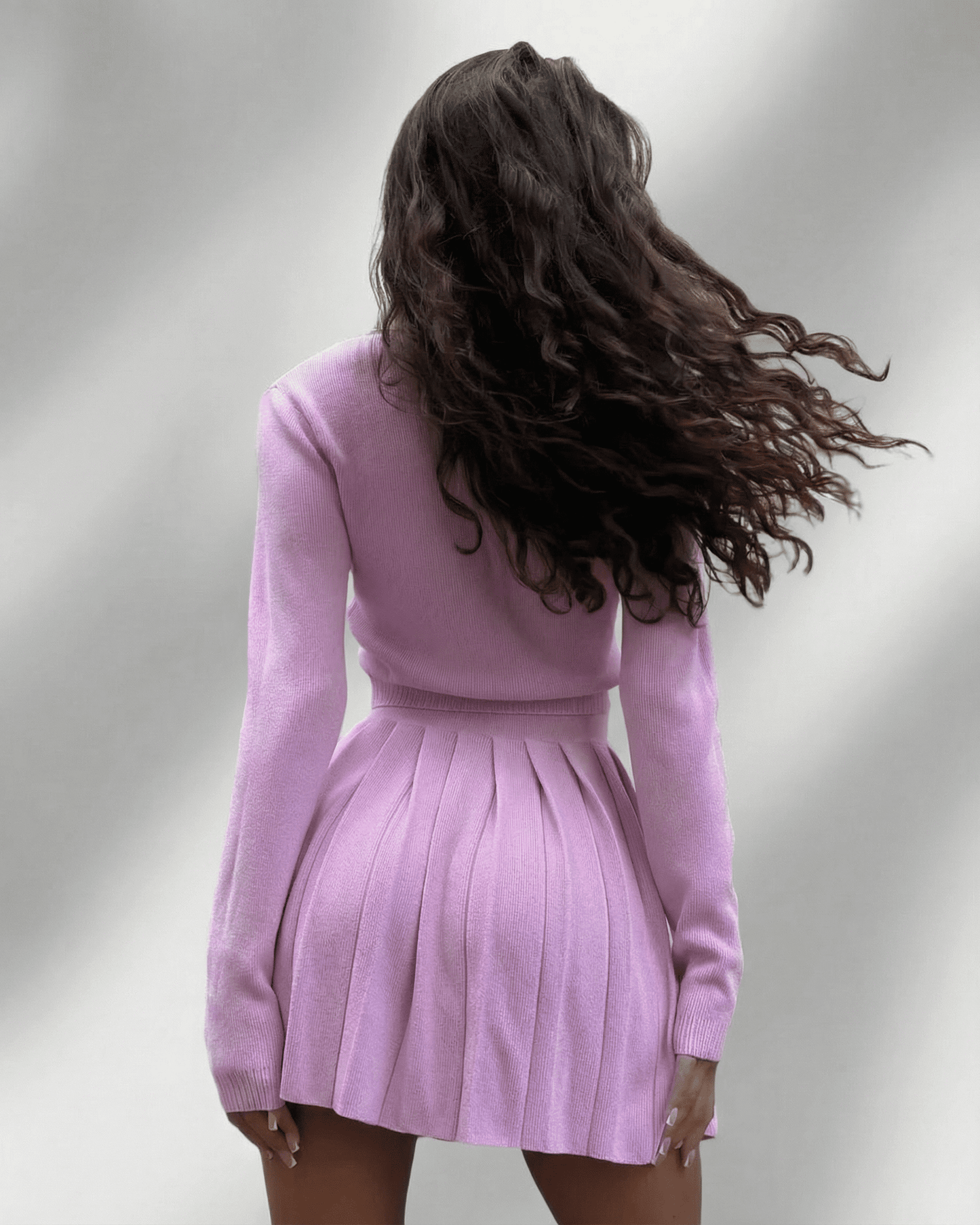 Lyra Two-Piece Set by SLIMONA featuring a soft knit cardigan and pleated mini skirt in pastel pink.