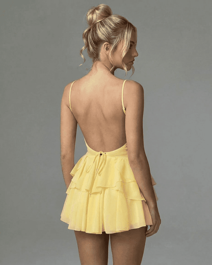 Marigold Mini Dress by SLIMONA - Back view of a ruffled yellow mini dress showcasing elegant spaghetti straps.