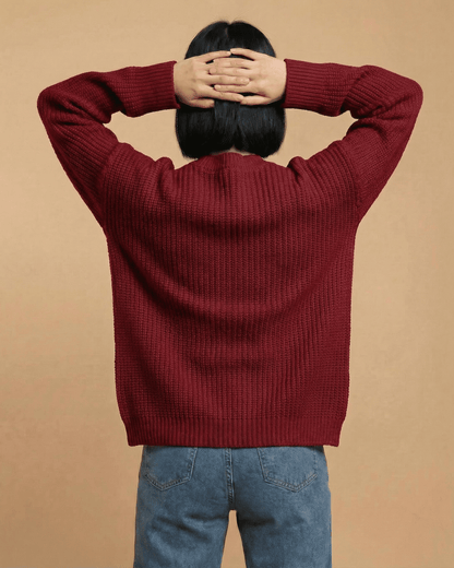 Back view of a woman wearing a burgundy Merano Cardigan by SLIMONA, showcasing its loose fit and knitted texture.