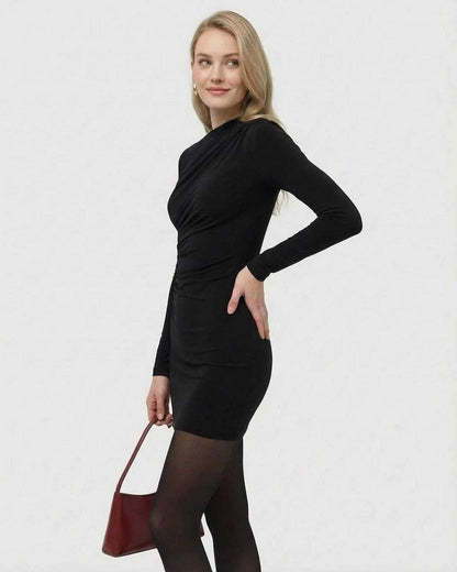 Woman modeling the Noiré Mini Dress by SLIMONA, featuring long sleeves, high waist, and sleek silhouette.
