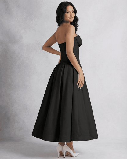 Model showcasing the elegant Nova Midi Dress by SLIMONA, featuring a strapless design and flowing A-line silhouette.