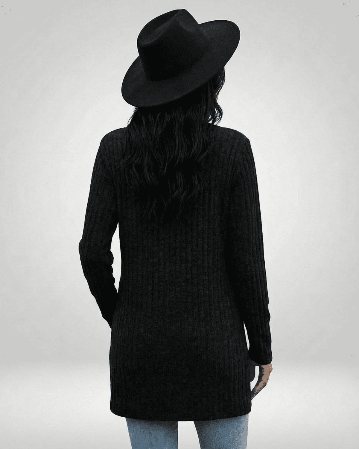 Back view of a woman wearing the Nyx Cardigan by SLIMONA, featuring a longline silhouette and a stylish black hat.