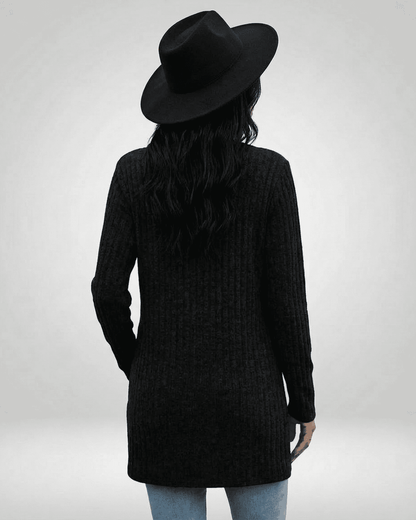 Back view of a woman wearing the Nyx Cardigan by SLIMONA, featuring a longline silhouette and a stylish black hat.
