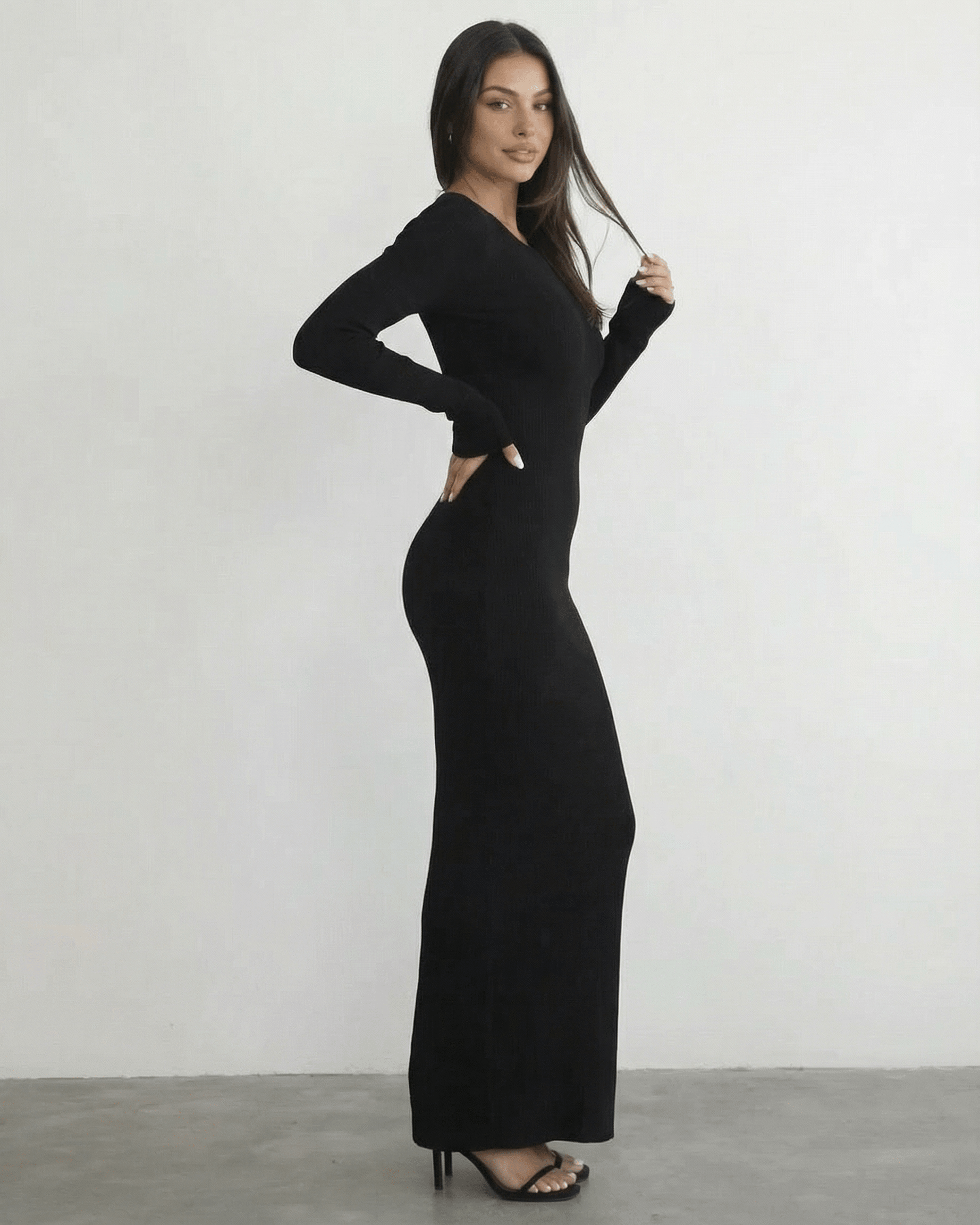 Model wearing the Nyx Maxi Dress by Lauven, a long sleeve black dress featuring an open back detail.