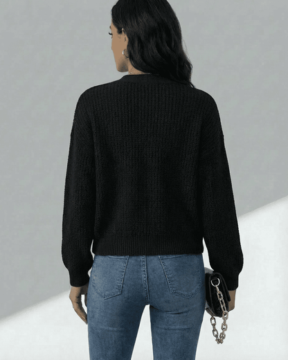 Woman wearing the Orion Cardigan in black, showcasing the back view with long sleeves and a casual fit by SLIMONA.