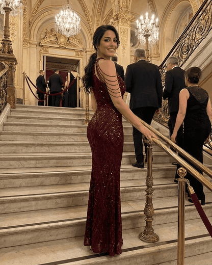 Model showcasing the Ruby Maxi Dress by SLIMONA, a glamorous sequin halter mermaid gown in deep red.