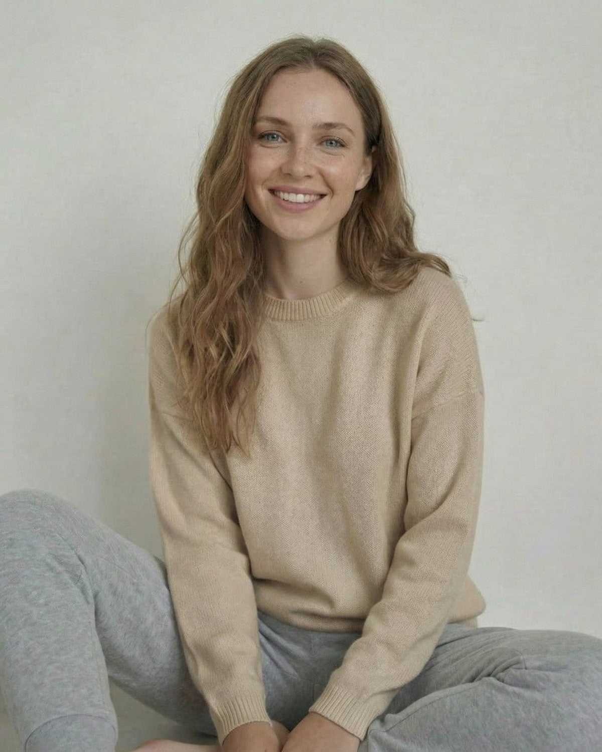 Siena Pullover in soft wool, showcased by a smiling woman in a relaxed pose, wearing SLIMONA's stylish design.
