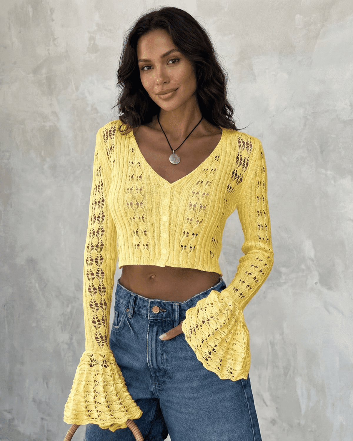 Stylish model wearing Solana Cardigan by SLIMONA, a yellow cropped cotton knit with flare sleeves.