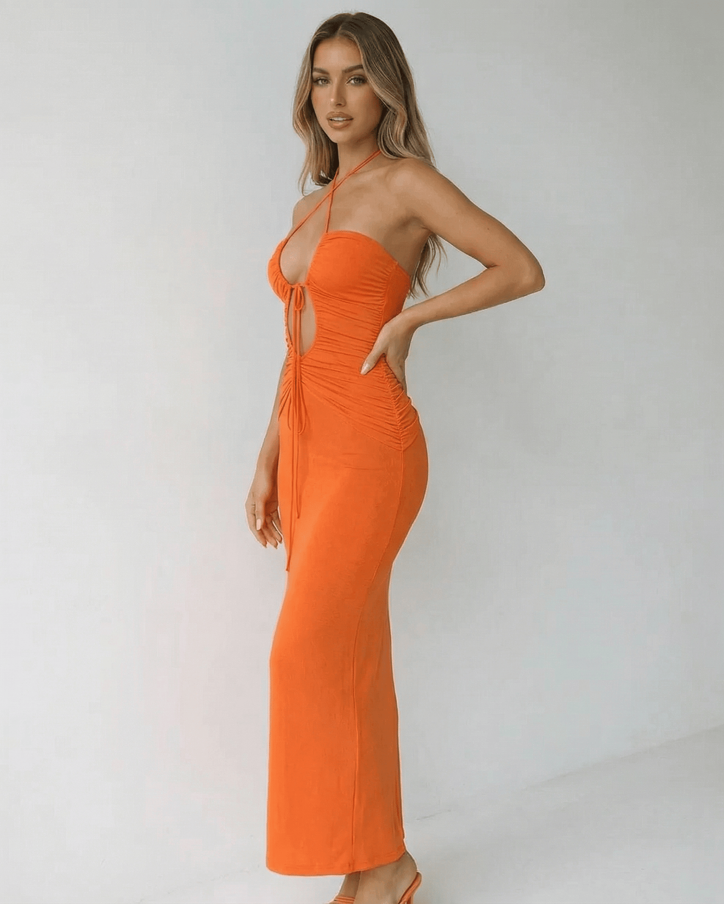 Solara Maxi Dress by Lauven, a sleek orange halter neck maxi dress with ruched details and ankle-length silhouette.