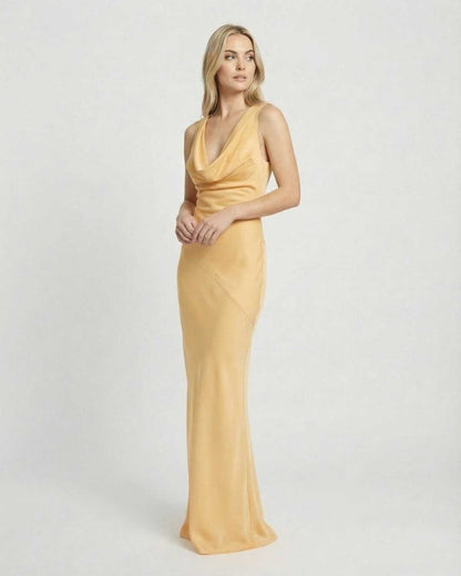 Model wearing Solara Maxi Dress by SLIMONA, a satin-effect cowl neck bodycon floor-length dress.