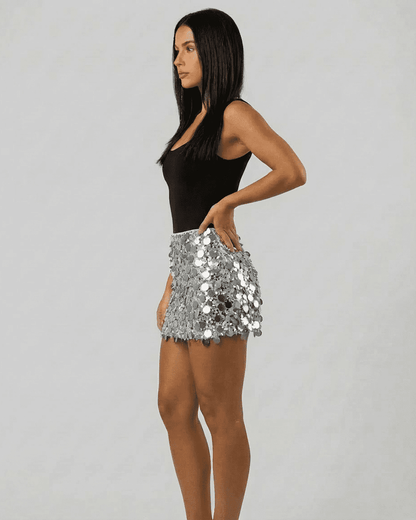 Model wearing the Sterling Mini Skirt by SLIMONA, showcasing its silver sequin hem and bodycon fit.