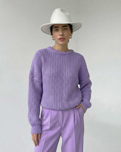 Lavande Sweater by Lauven, featuring a textured knit in lavender, paired with stylish trousers and a wide-brimmed hat.