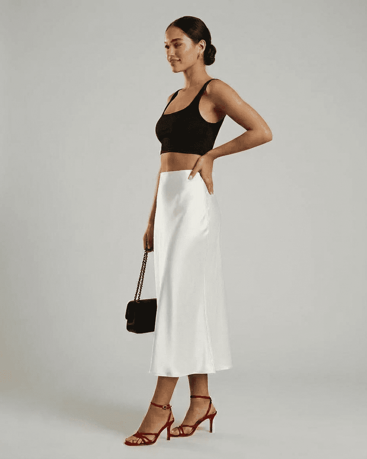 Model wearing Luna Midi Skirt by SLIMONA, showcasing its elegant satin design and refined silhouette.