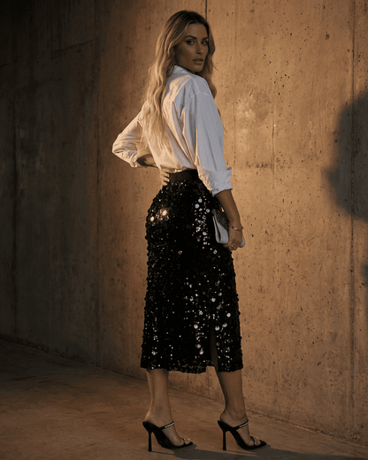 Model showcasing the Noctura Midi Skirt by SLIMONA, a black sequin bodycon midi skirt for elegant occasions.