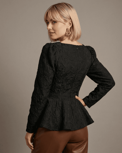 Noir Corset Top by SLIMONA, showing the back view with a peplum design and textured jacquard fabric.