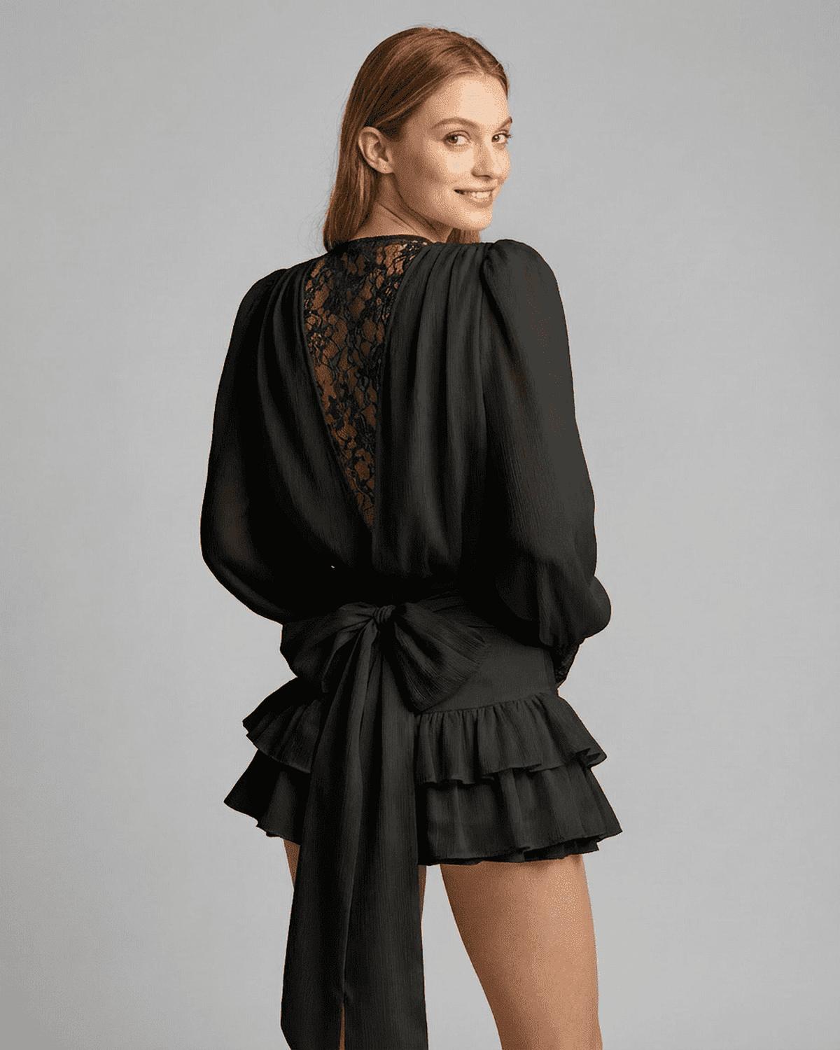 Noir Mini Dress by SLIMONA featuring lace detail, V-neck, and tiered silhouette on a model.