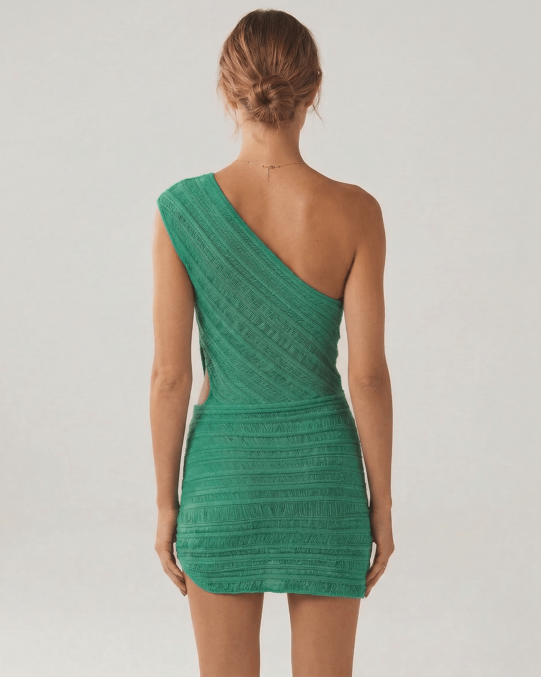 Back view of the Viridian Mini Dress by Lauven in vibrant green, showcasing its unique asymmetrical design.