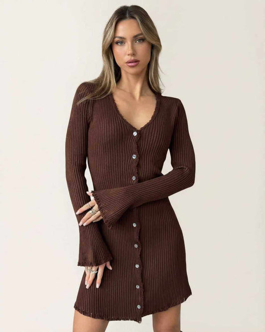 Model wearing the Orion Mini Dress by Lauven, a ribbed bodycon mini dress with flare sleeves and button details in deep chocolate brown.