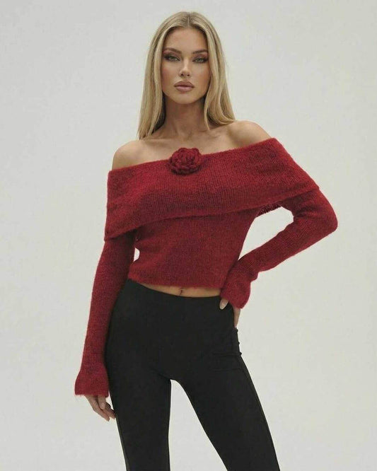 Woman in red Verona Pullover off the shoulder sweater by Lauven, featuring long sleeves and a stylish rose detail.
