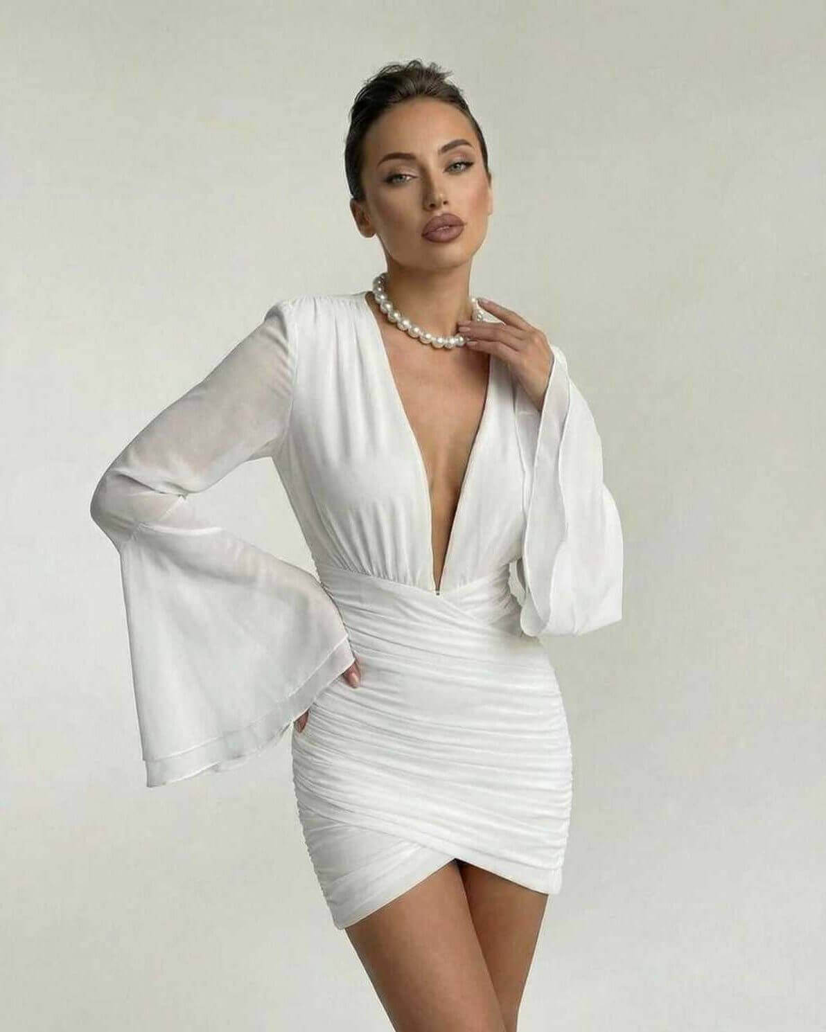 Celeste Mini Dress by Lauven featuring a V-neck, ruched sheath silhouette, and sheer dramatic sleeves.