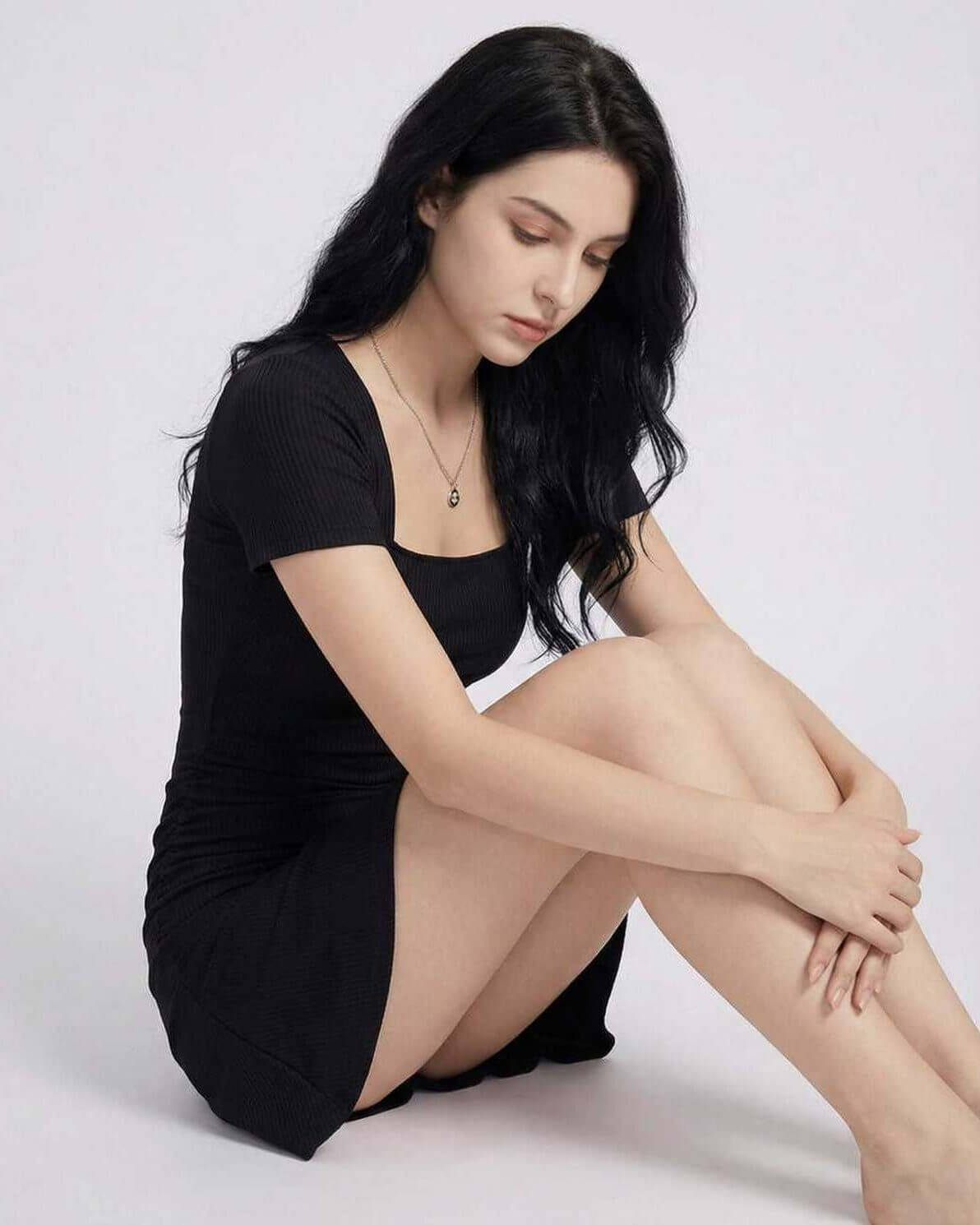 Hera Mini Dress by Lauven, showing a model in a sleek black sheath silhouette with a square neckline.