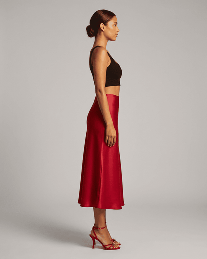 Model in profile wearing the Rosalia Midi Skirt by SLIMONA, showcasing its elegant satin mermaid design.