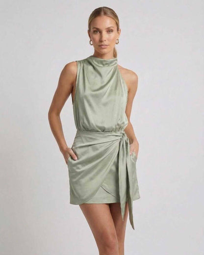 Sahara Mini Dress by Lauven in soft sage green with draped high neck and wrap tie detail, perfect for elegant occasions.