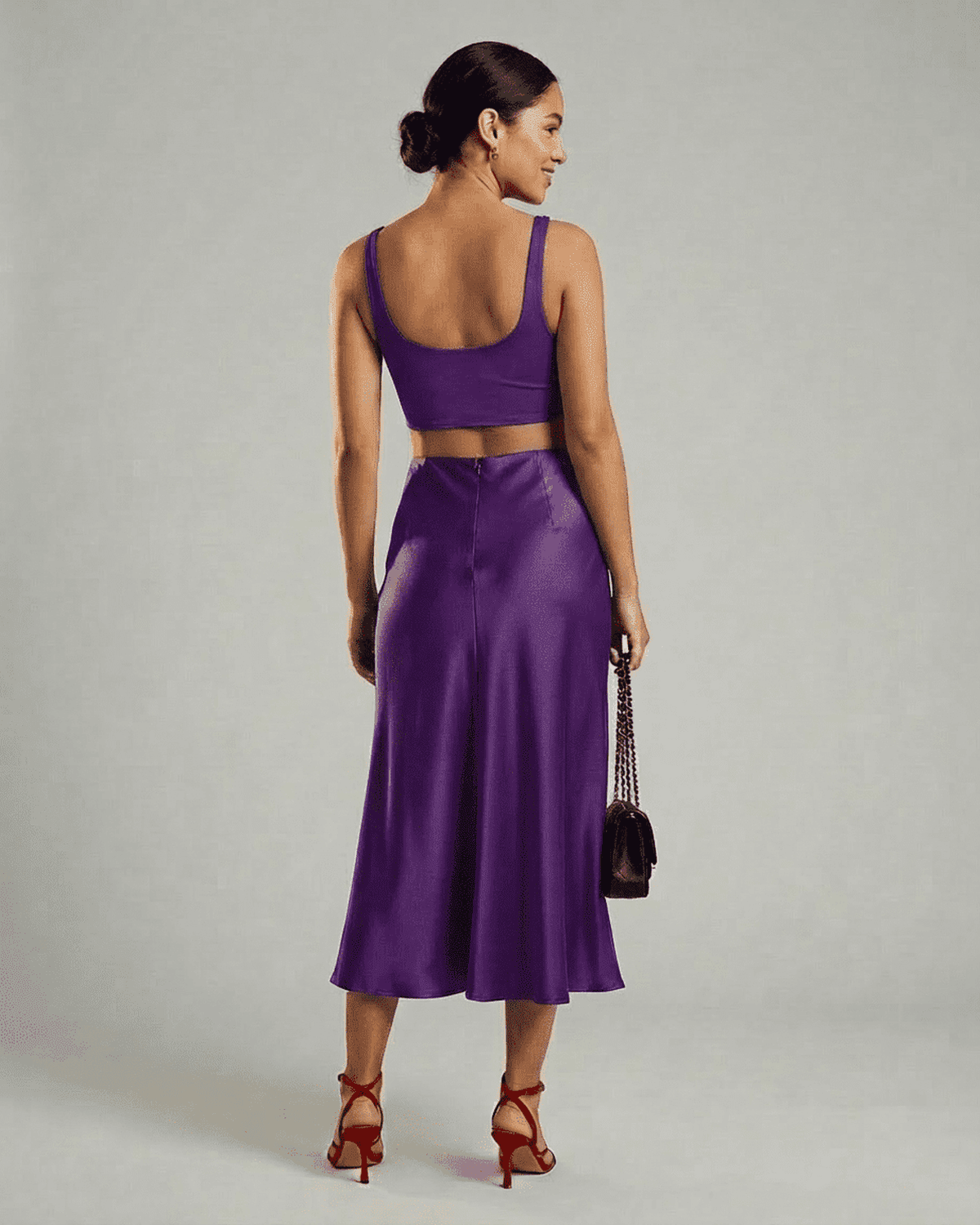 Model showcasing the Amethyst Midi Skirt by SLIMONA, featuring a satin mermaid design in a vibrant purple hue.