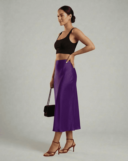 Model wearing the Amethyst Midi Skirt by SLIMONA, showcasing elegant movement and rich purple hue.