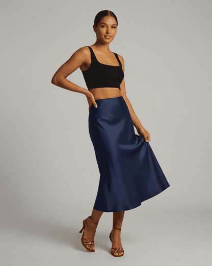 Model wearing Astra Midi Skirt by SLIMONA, a satin mermaid skirt in deep navy blue, showcasing elegance and style.