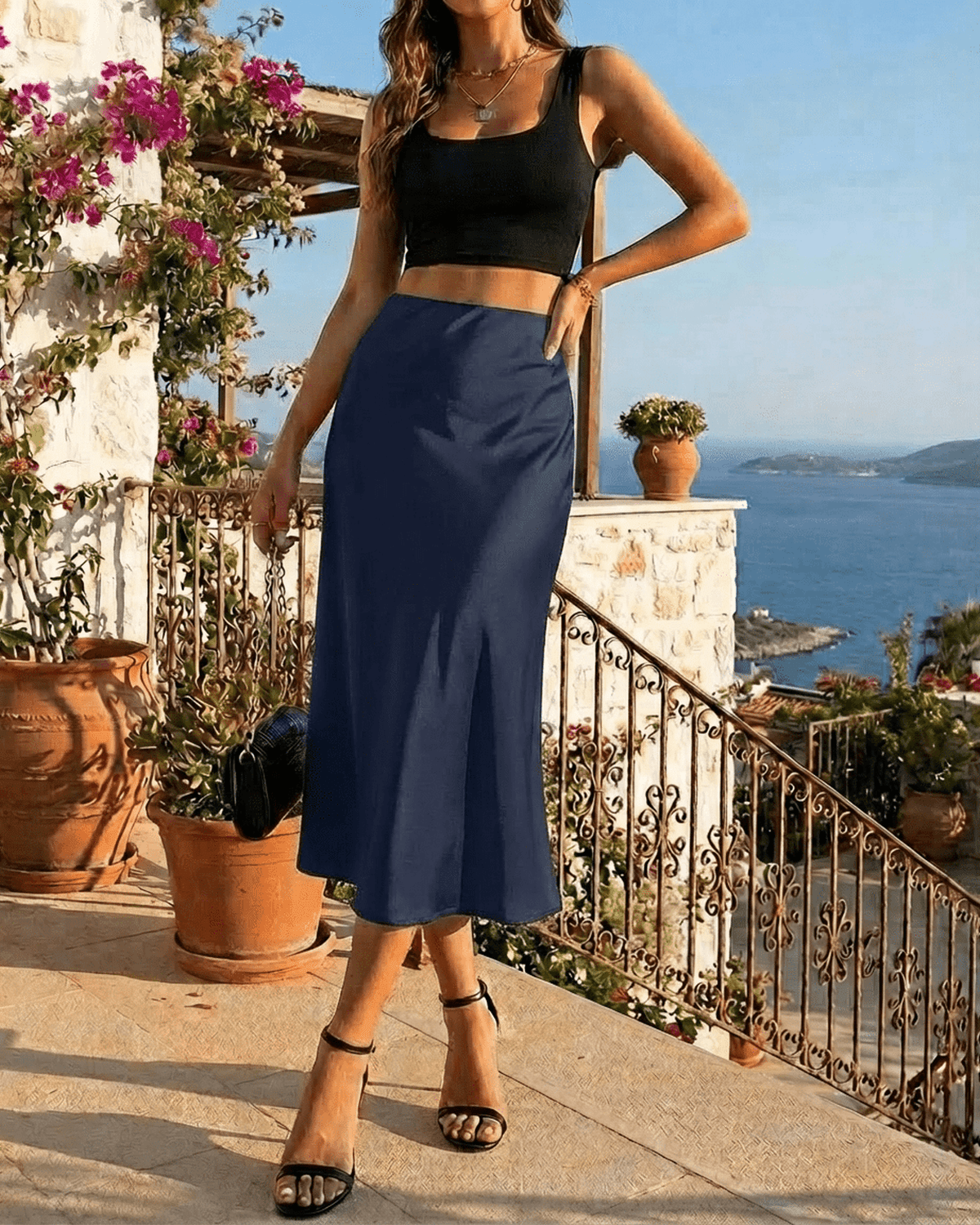 Astra Midi Skirt by SLIMONA - Elegant navy satin mermaid midi skirt paired with a black crop top in a scenic setting.