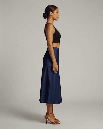 Astra Midi Skirt by SLIMONA in deep navy blue, showcasing a sleek silhouette and elegant design.