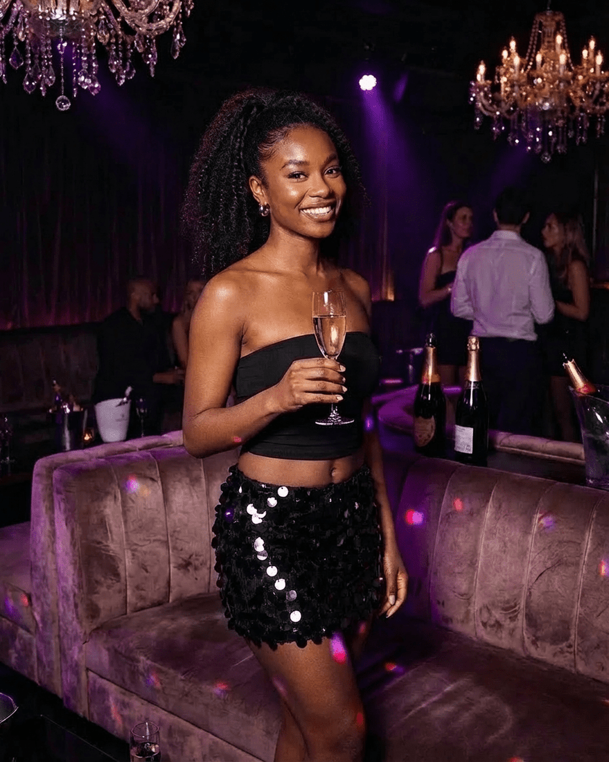 Stylish woman wearing Noir Mini Skirt by SLIMONA, featuring all-over black sequins at a chic evening party.